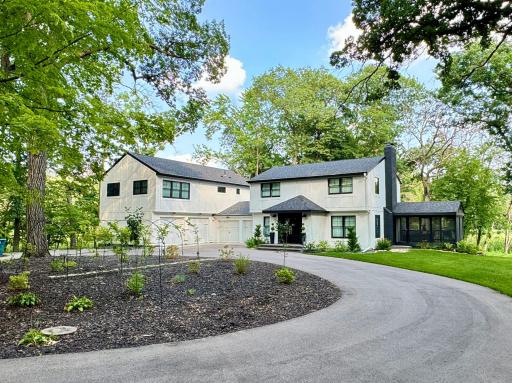 roundabout driveway with large mature trees surrounding the property