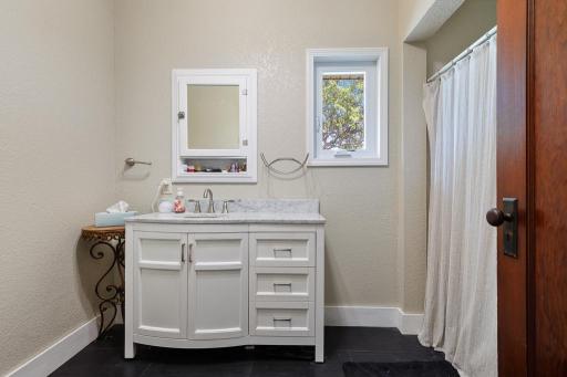 The full bathroom features a new vanity with marble countertop (2022)