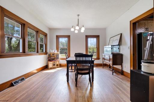 Windows surround this spacious dining room and the original woodwork makes them pop - stunning