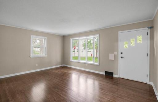 Living room with many windows and refinished hardwood floors