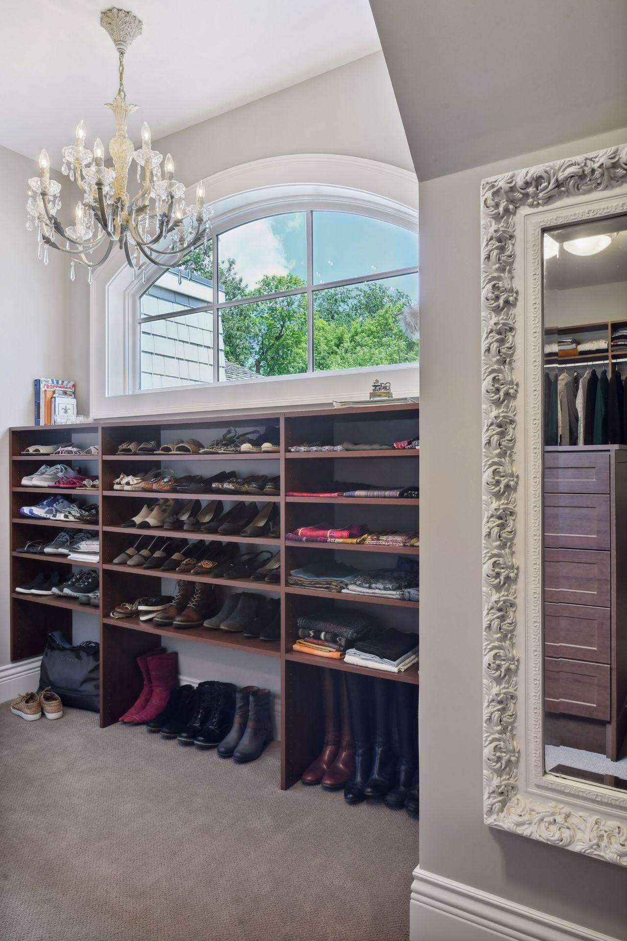 Hers closet with shoe racking and chandelier