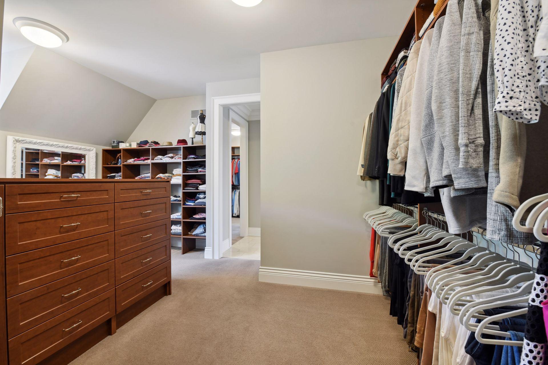 Hers walk-in closet with packing station, dresser, shoe and clothing racking