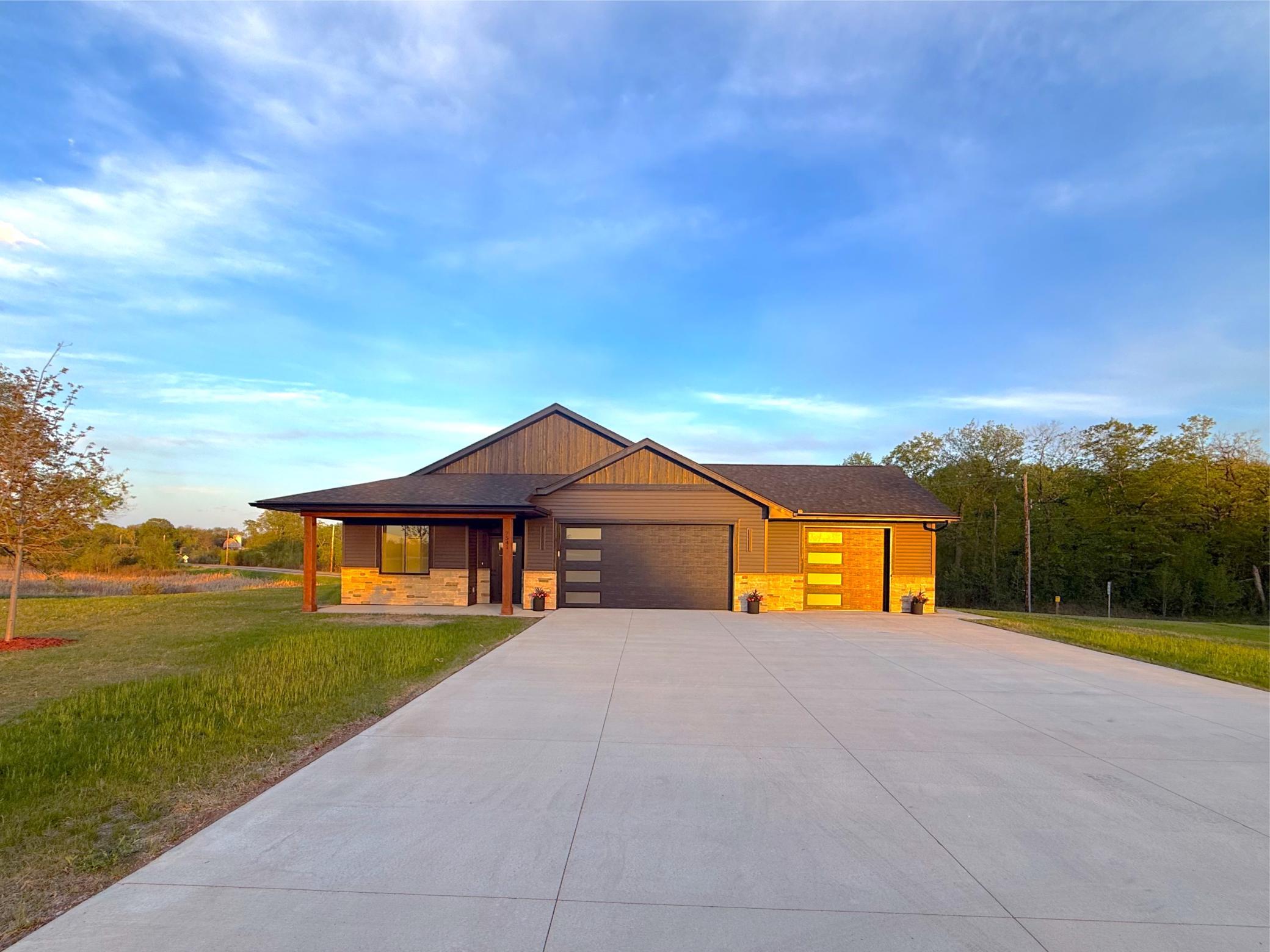 The modern color scheme blends wonderfully in the development. The sprinkler system and lawn seeding has been completed. The concrete driveway complements the oversized garage.