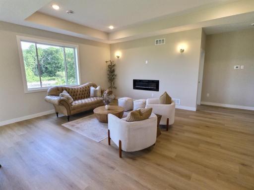 The living room will be open and spacious and centered by an electric fireplace. The box ceiling is in both the living room and primary bedroom. Large windows line this wall to allow the natural light to flow through the home.