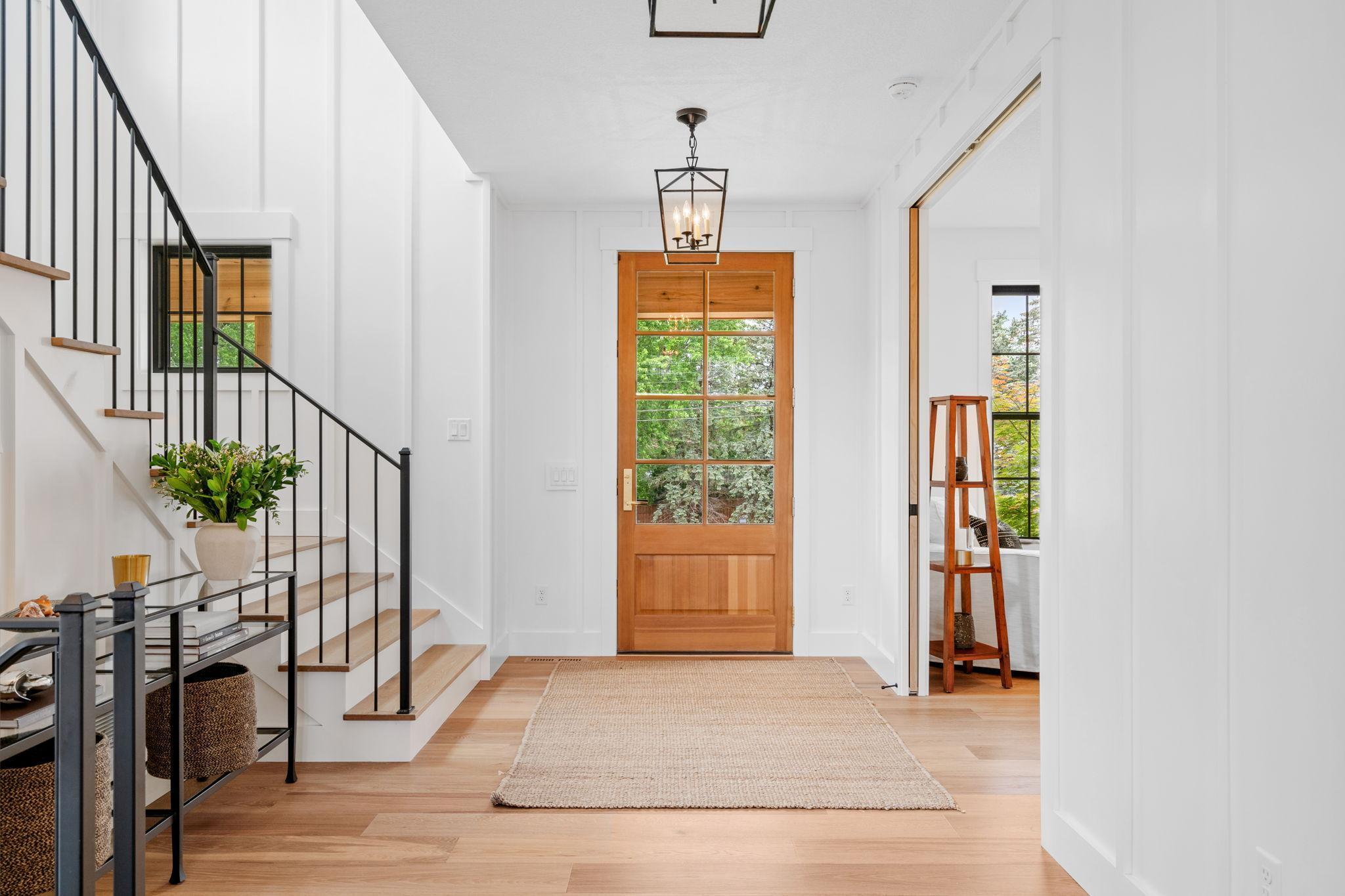The grand entry of this home is a breathtaking introduction to its elegant interiors, designed to welcome guests with style. Upon entering, you are greeted by soaring ceilings adorned with chandeliers that cast a warm, inviting glow.