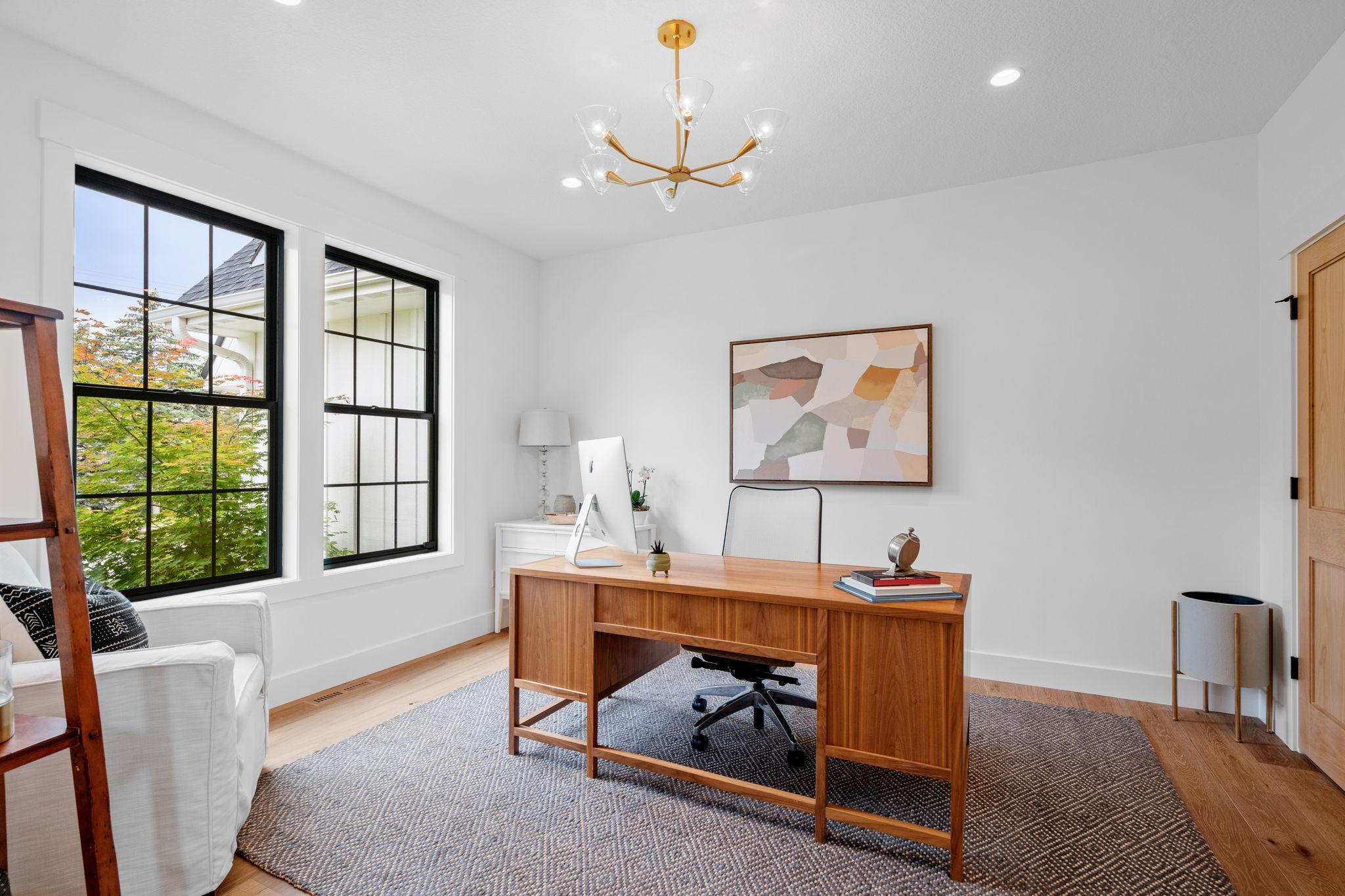 Adjacent to the entryway is a refined office, accessible through a stylish glass pocket door that enhances the room’s openness while providing privacy when needed. Inside, recessed lighting ensures a bright and focused work environment.