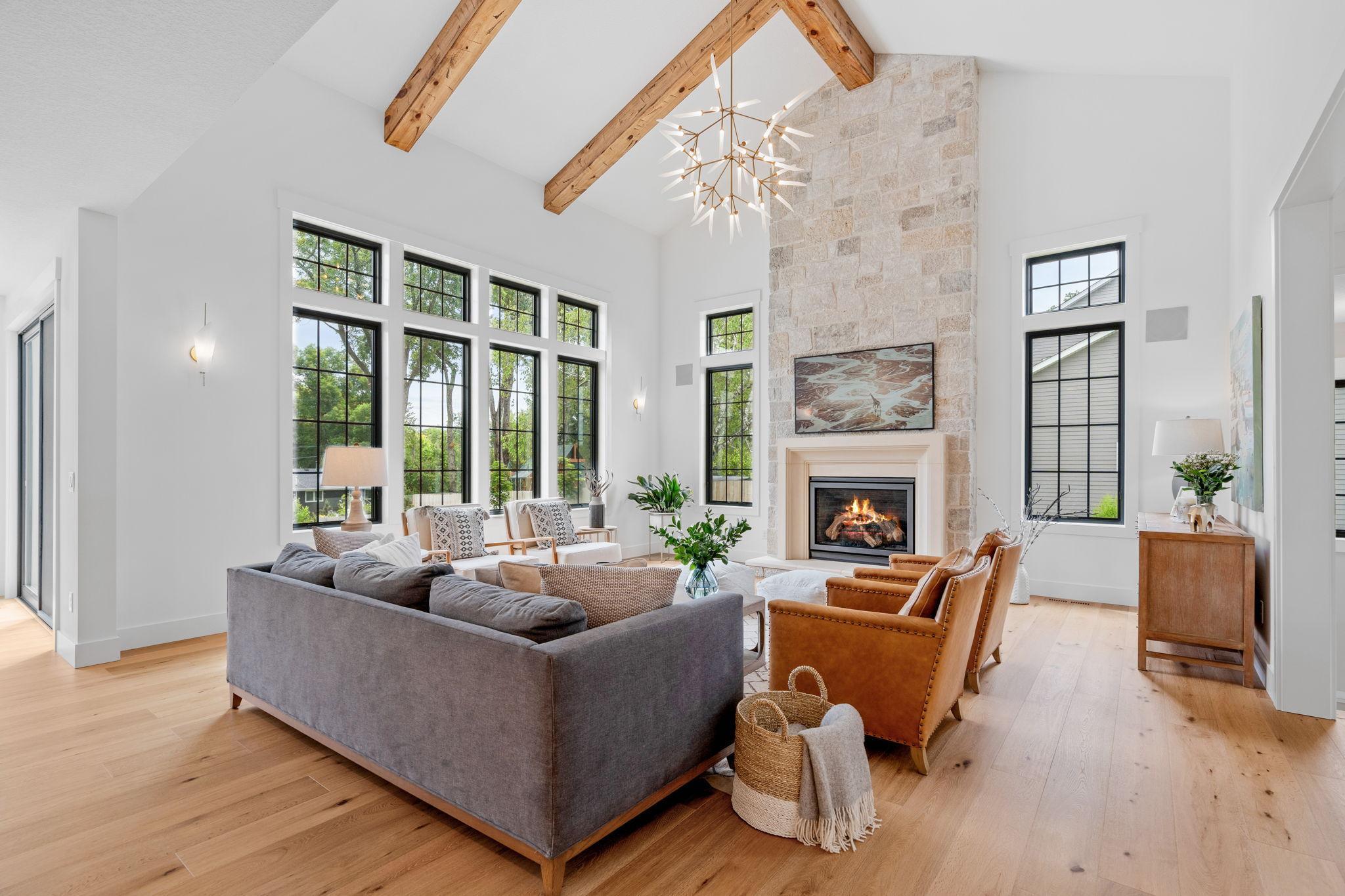 The living room exudes grandeur with its impressive 17-foot vaulted ceiling, where wood beams add rustic charm and a sense of warmth.