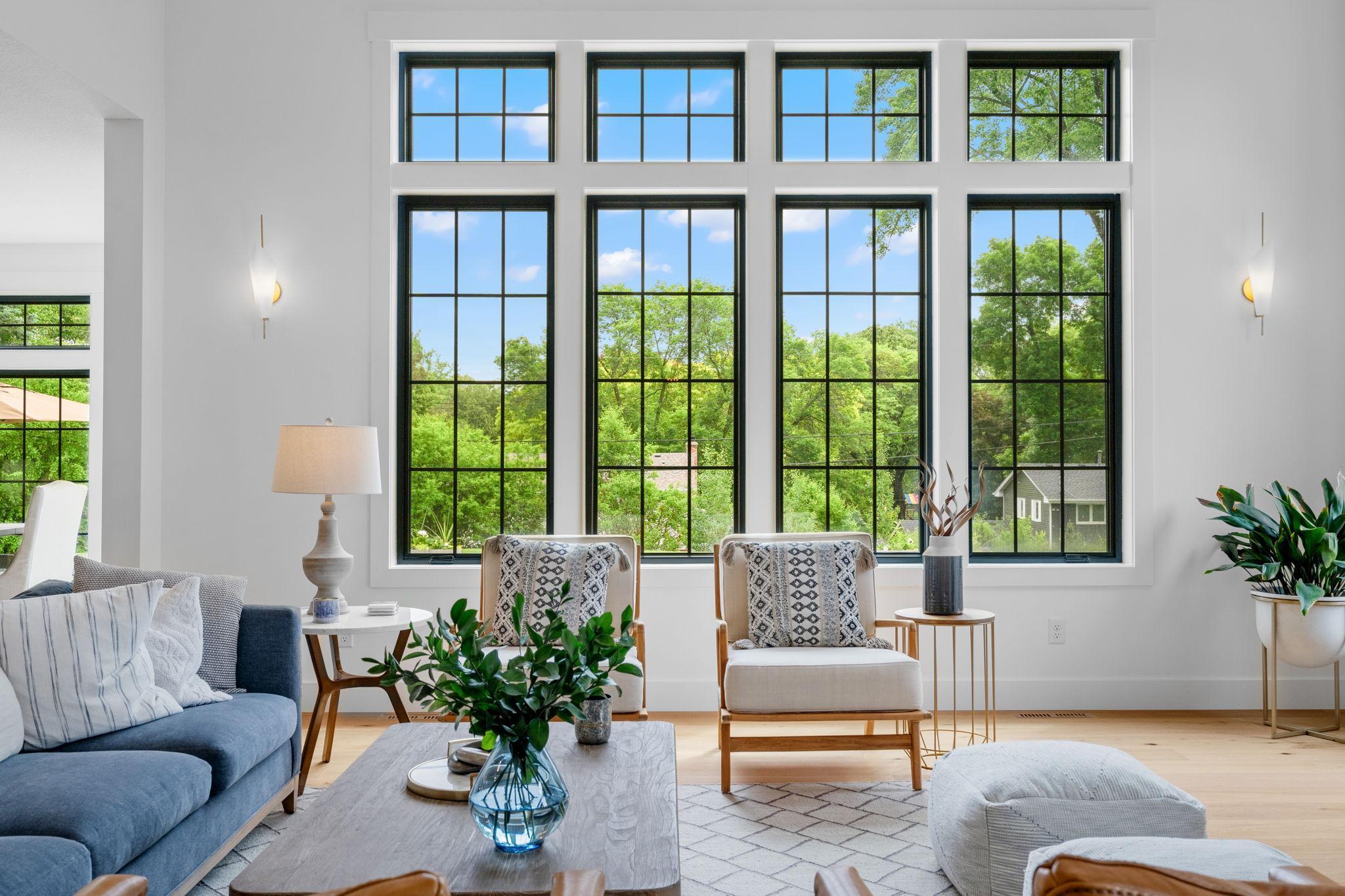 Natural light floods the space through expansive Pella windows, which not only provide breathtaking views of the outdoors but also create an airy, open atmosphere.