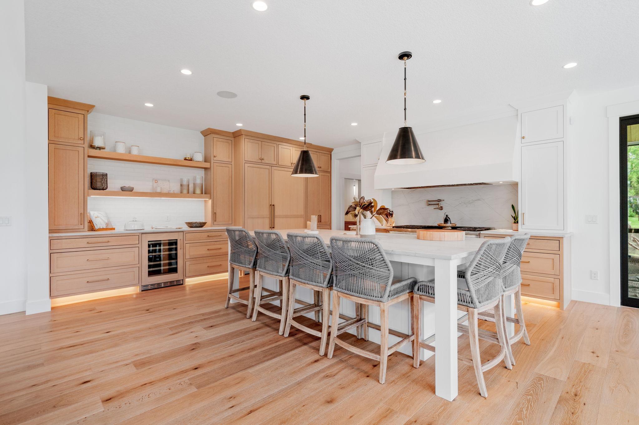 Strategically placed recessed lighting illuminates the entire kitchen, creating a bright & welcoming space. Custom white oak quartersawn cabinets throughout provide a timeless & elegant aesthetic, complemented by inset soft-close cabinets and drawers