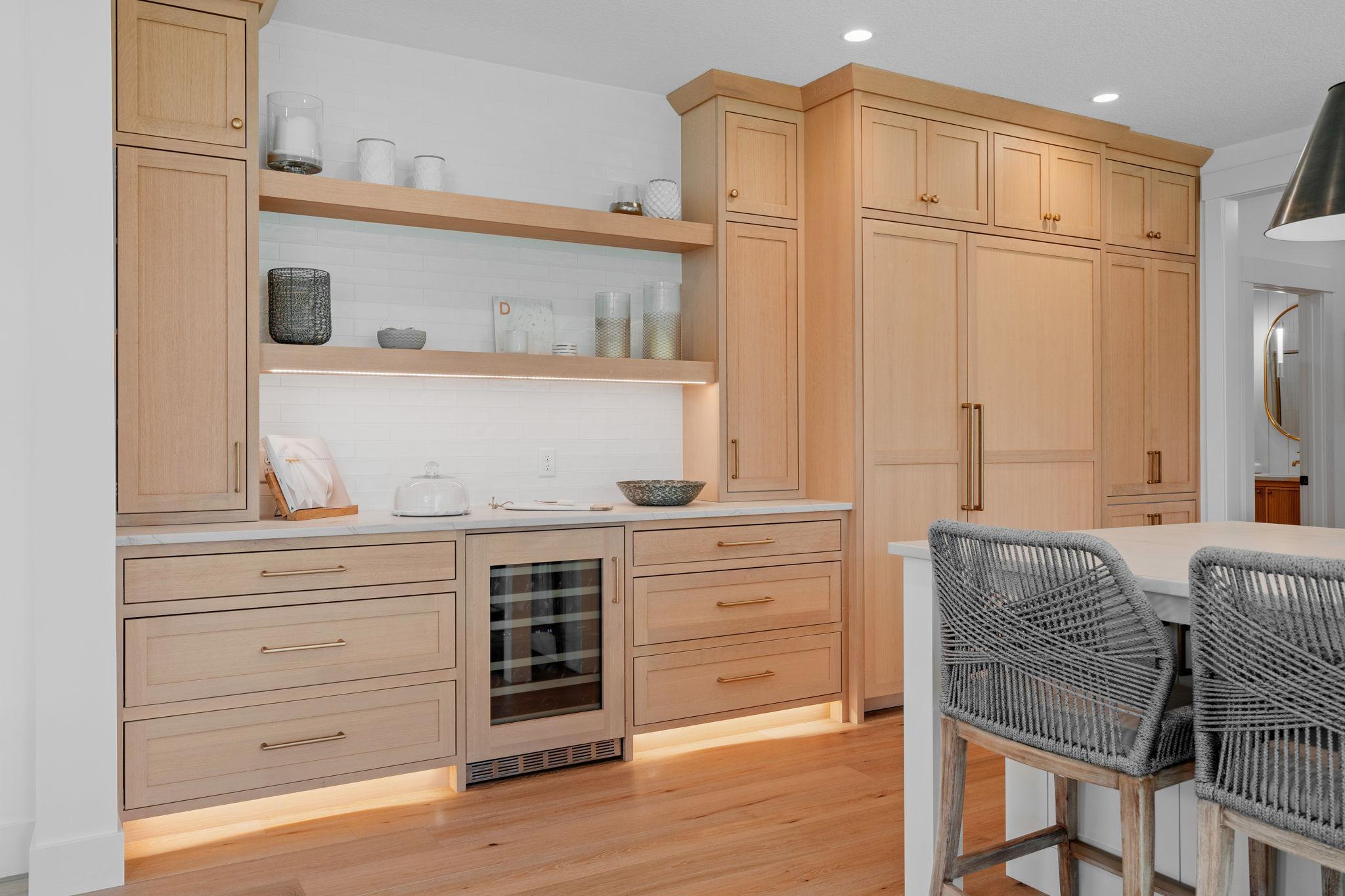 Step into luxury in this gourmet kitchen outfitted with this practical wine bar with tile back splash, soft close cabinets & drawers through out, counter depth Thermador panel refrigerator. Also includes tow kick lighting adding to the ambiance.