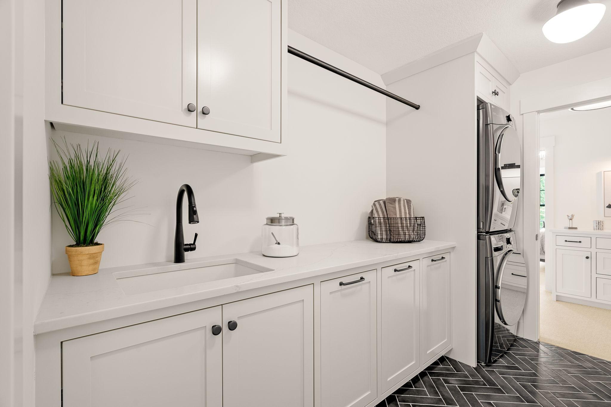 The laundry room, adorned with exquisite herringbone tile flooring, exudes sophistication at every turn. You will find built-in cabinets crafted to perfection, offering ample storage solutions to keep your essentials organized and easily accessible.