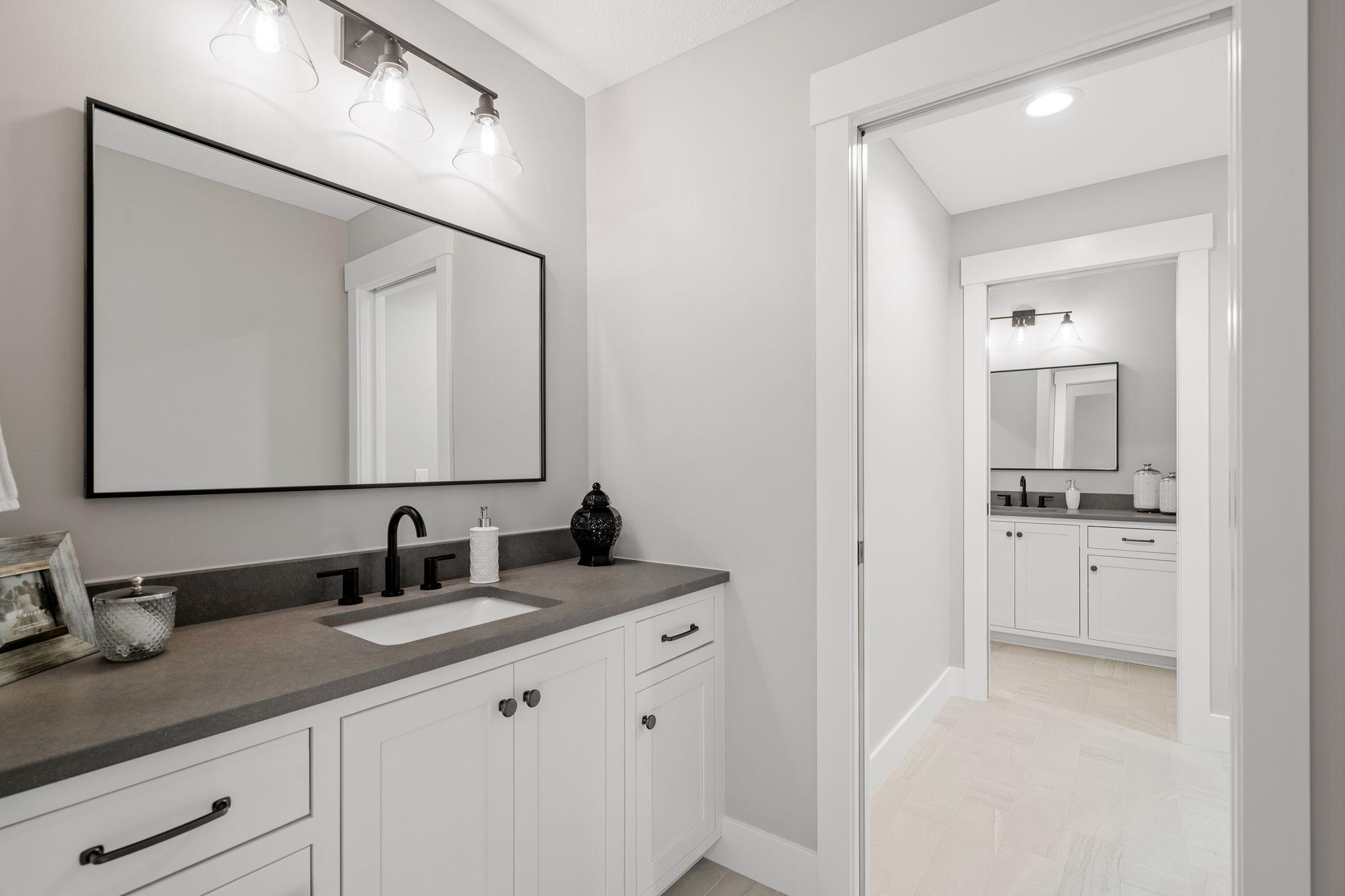 Connected through the doorway lies the Jack and Jill bathroom, a masterpiece of modern design. Reflective mirrors and contemporary fixtures enhance the ambiance, creating a sanctuary where guests can pamper themselves in style.