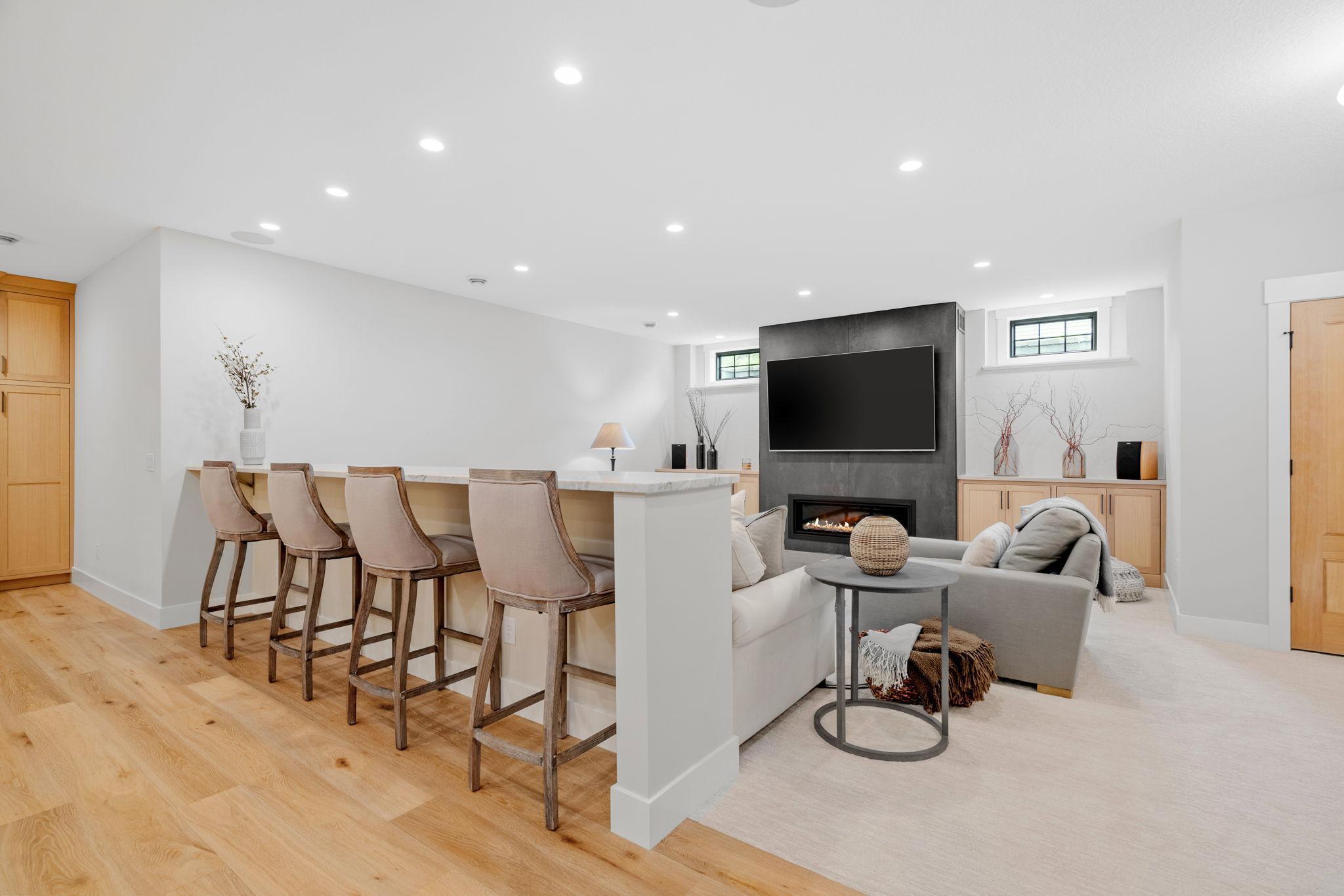 The spacious family room is perfect for gatherings, equipped with extra seating along a sleek quartzite countertop.