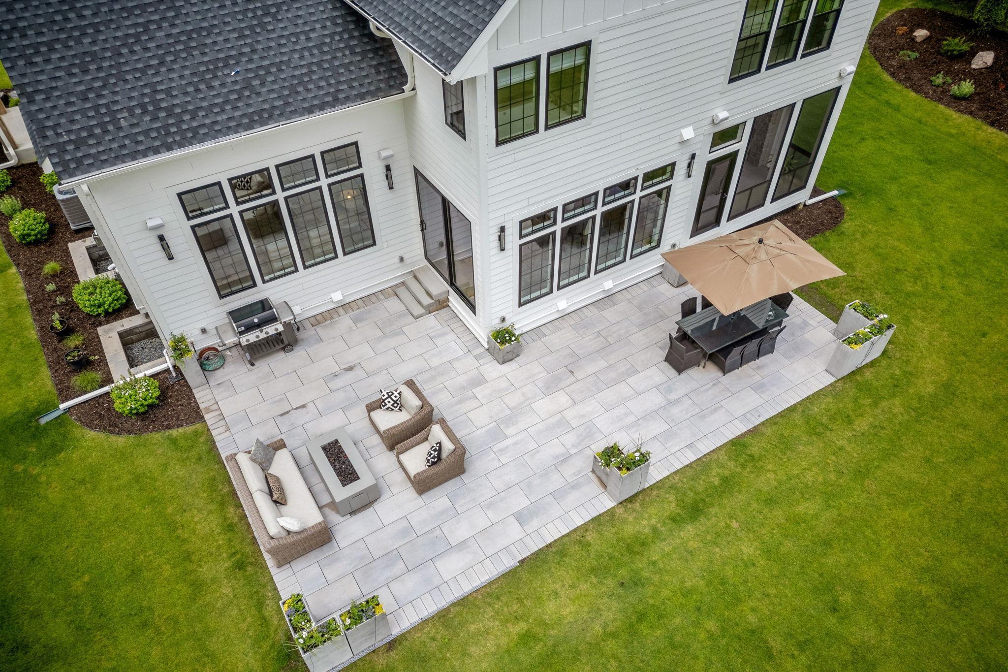 The backyard features a premium Techo-Bloc paver patio, providing a stylish and durable foundation for outdoor furniture and entertainment.