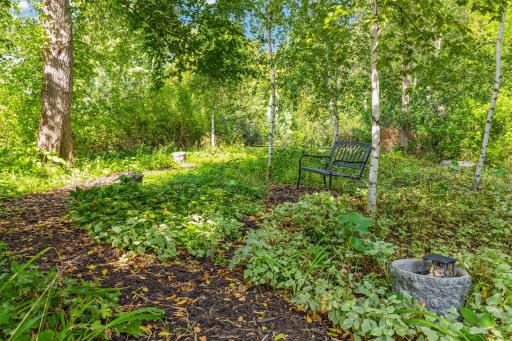 The serene landscaping offers a Fairy Garden, fern garden & thousands of plants.