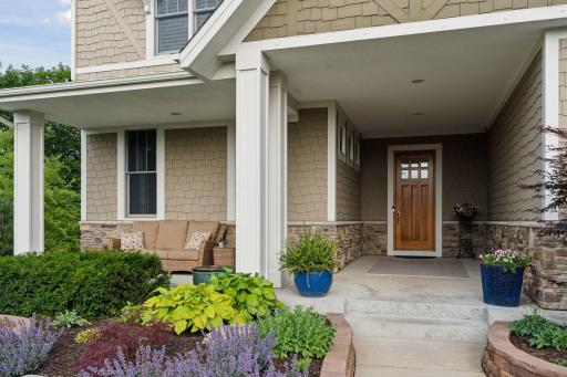 Welcoming front entry way with lovely perennial gardens and covered porch.