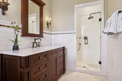 Ensuite bathroom has custom cabinets, marble floors with in-floor heat, and walk-in shower.