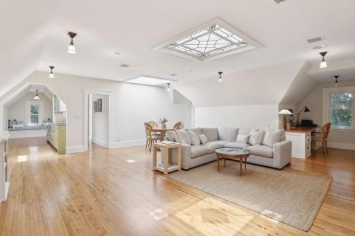 3rd floor living area has plenty of space for dining table and office. Stained-glass windows/skylight were custom designed to match other stained glass in the house.