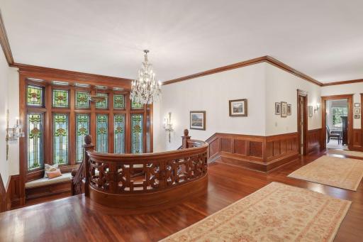 Exquisite carved mahogany in the staircase. And dramatic 7-ft wide hallway continues on the upper level.