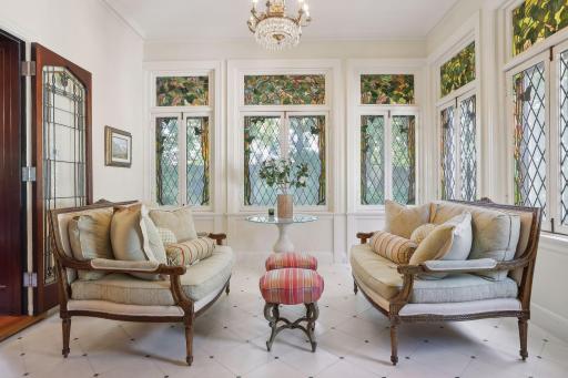 Sunroom has in-floor heat and gorgeous, original stained glass windows.