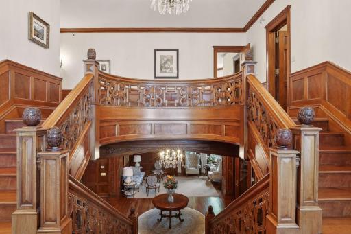 The dramatic 7-ft wide grand staircase, adorned with exquisite carved mahogany, leads you to the upper level."