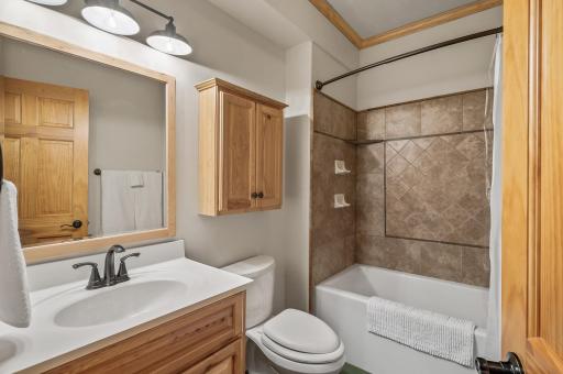 Full bathroom on the lower level with tile surround and heated concrete floors.
