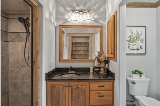 The primary suite hosts a walk-in closet with lots of room, a steam shower, vanity area with copper sink and sliding barn door for privacy.