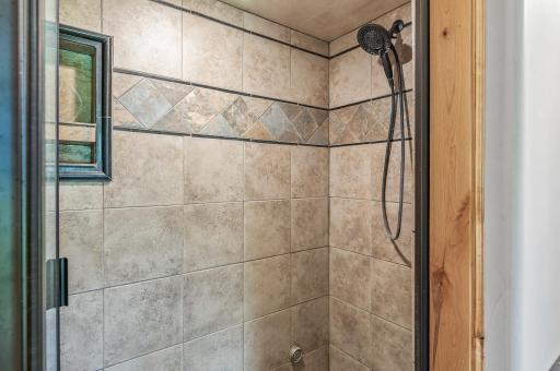 Primary bathroom walk in shower with tile surround.