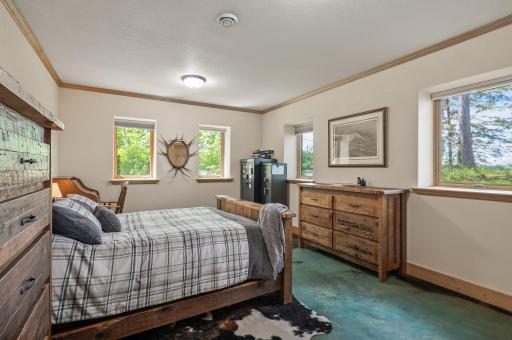 Bedroom #3 on the lower level has lookout windows facing the lake and heated painted concrete floors.