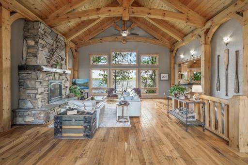 Step into the breathtaking great room, where white pine beams accentuate the 20-foot vaulted ceiling, creating an airy and spacious atmosphere.