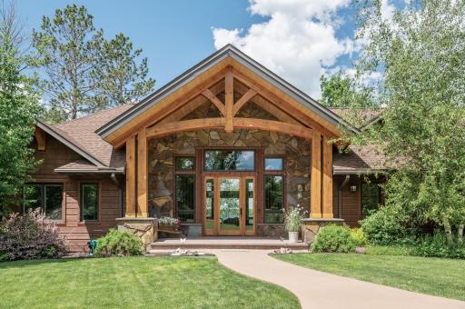 Pull into the circular drive and approach the welcoming front porch, where a glass front door surrounded by windows beckons you inside.