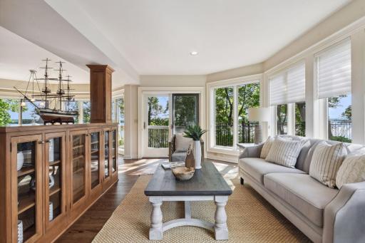 Sunroom just off the kitchen with access to deck and walls of windows and gas fireplace