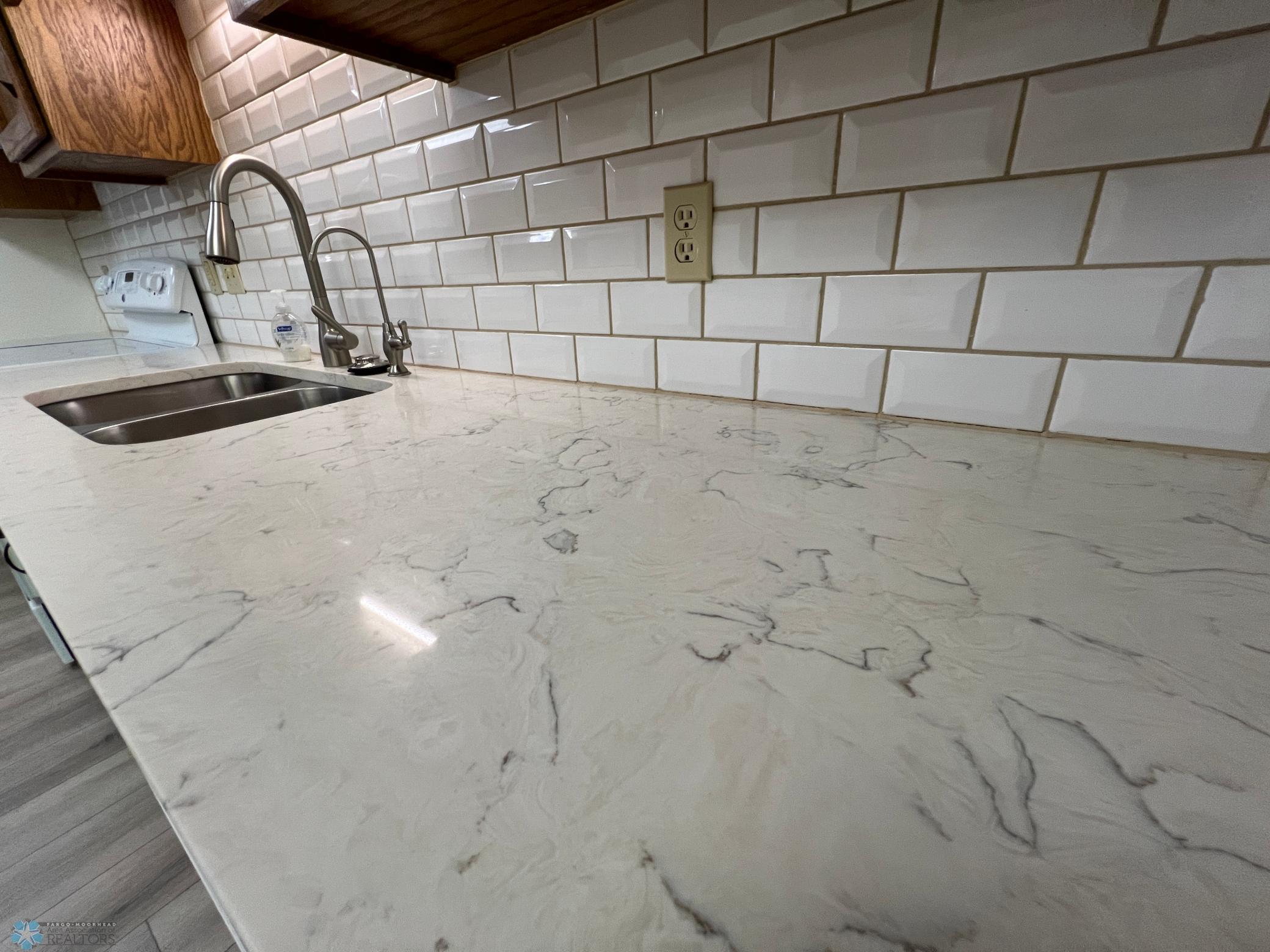 New quartz counters, tile backsplash, and faucets