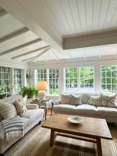 The living room is full of windows and interesting woodwork.