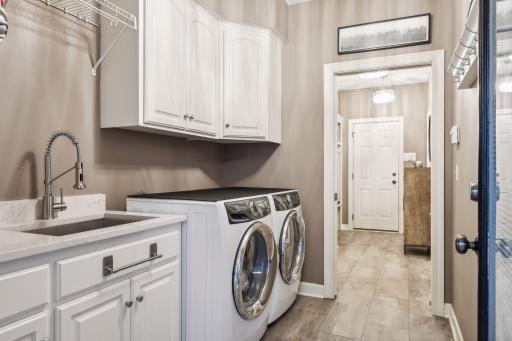Convenience is at the heart of this laundry room. An undermount sink with a modern faucet allows for easy hand-washing and spot treatment of garments, while the laundry chute simplifies the process of collecting clothes from different floors.
