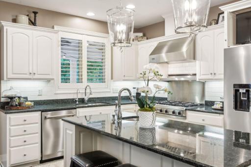 The island features sleek granite countertops and comfortable seating, making it an ideal spot for morning coffee, quick bites, or engaging conversations while cooking.