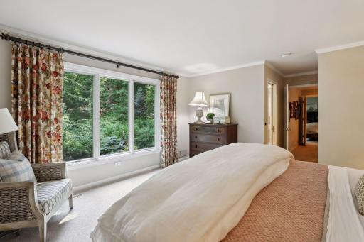 The primary bedroom overlooks the lush backyard landscaping creating a relaxing retreat.