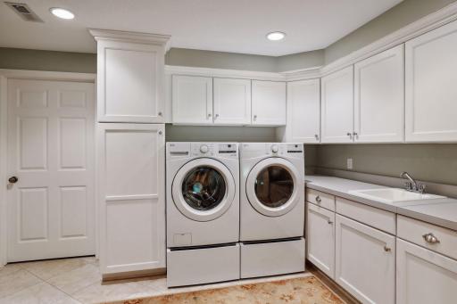 Huge laundry room with tons of storage and utility sink.