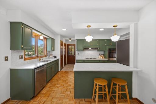 Amazing kitchen updates include enameled kitchen cabinets, almost all new appliances, quartz countertops and tile backsplash which contrast beautifully with the original parquet flooring!