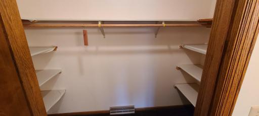 Walk-in closet in dressing area of primary bedroom