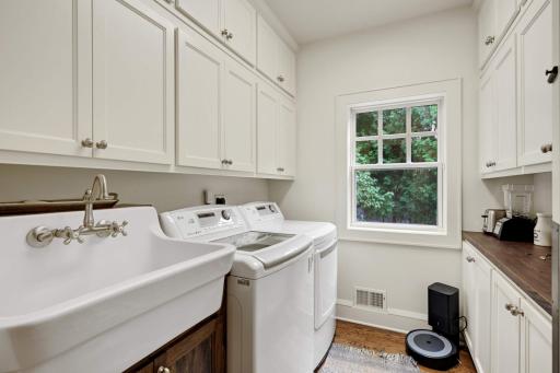 This space works double duty! A charming wash sink, abundance of cabinetry, washer/dryer make laundry, dare I say, enjoyable? The opposite side features a butcher block counter top and makes a fabulous butlers pantry!