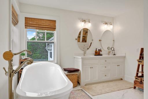 Take a deep breath and relax in this stunning primary bath. Draw some warm water and soak in this stand alone tub. Every surface of this bathroom was refinished in 2018 including a built in linen closet opposite the dual sinks of the vanity.