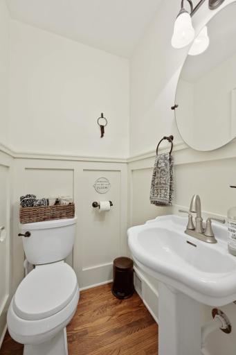Located between the formal and informal spaces is this darling powder room with wainscoting clad walls and pedestal sink.