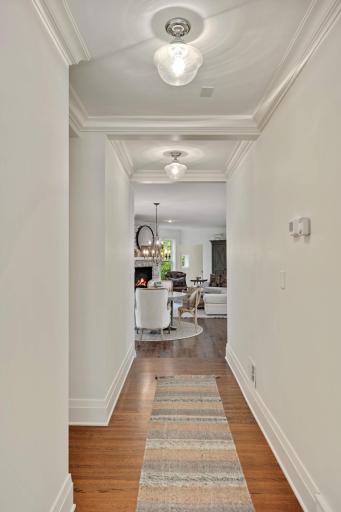 Coffered ceilings frame the hallway from the formal living room to the main living space of this home.