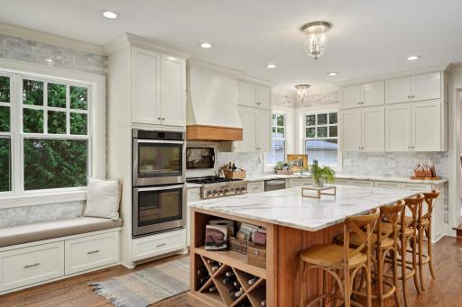 The custom built island features a wine rack and storage. It's complimented by a darling bench seats with more storage in the drawers beneath.