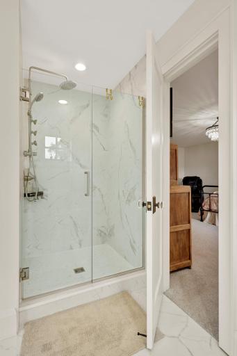 A fantastic walk in shower features floor to ceiling surround and frameless shower door.