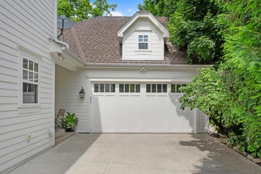The attached two car garage features a concrete parking pad and is discretely tucked back from the street.