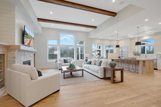 The living room features lofty ceilings and expansive windows allowing natural light to pour in.