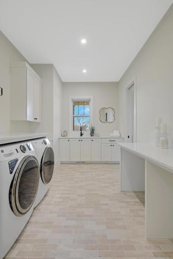 The main floor laundry room includes built-in cabinets and folding area.