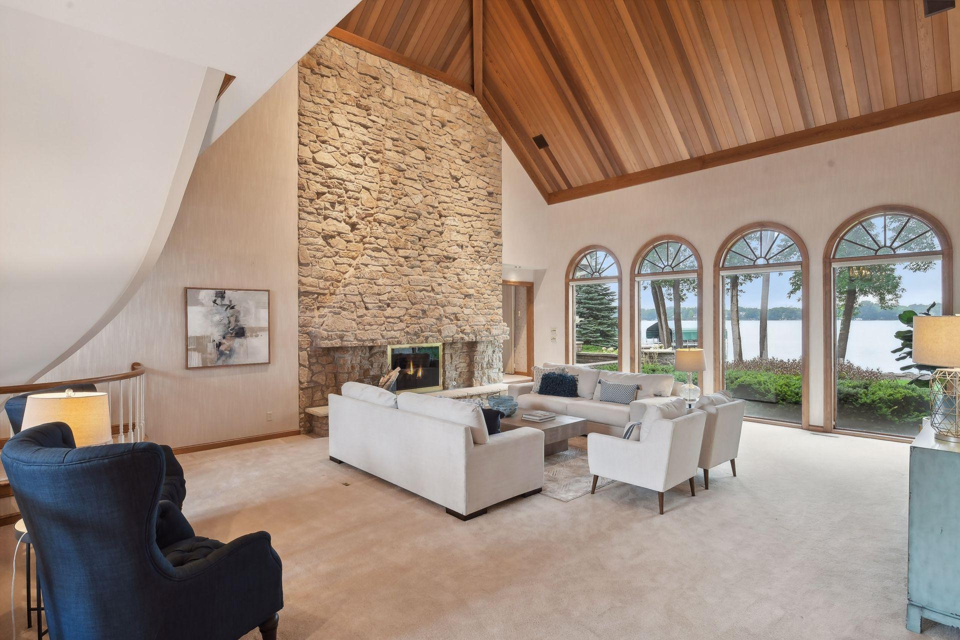 Incredible stone floor to ceiling fireplace in this main floor family room. Vaulted wood ceilings and lake views!